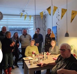 Buren om feestelijke tafel en slingers aan het plafond
