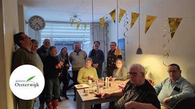 Buren om feestelijke tafel en slingers aan het plafond