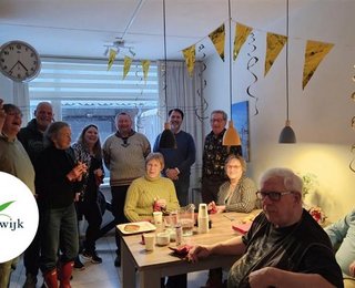Buren om feestelijke tafel en slingers aan het plafond