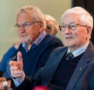 twee oudere mannen die aan tafel zitten
