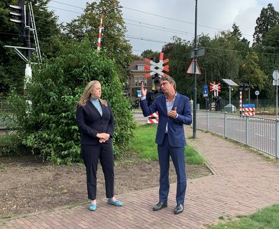 Wethouder en directeur ProRail bij spoorwegovergang