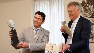 Eric Logister krijgt beeldje uit handen van Hans Janssen