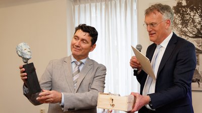 Eric Logister krijgt beeldje uit handen van Hans Janssen