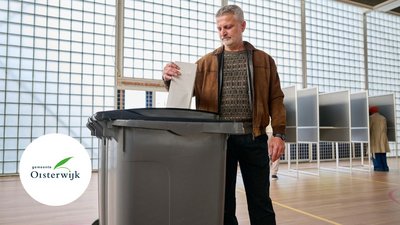 Man stopt stembiljet in de stemcontainer
