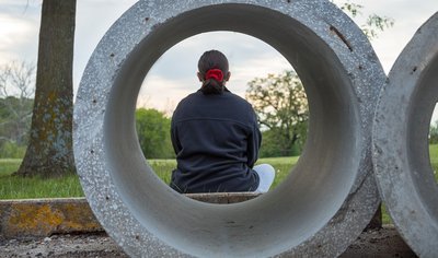 Vrouw staart voor zich uit in een rioolbuis