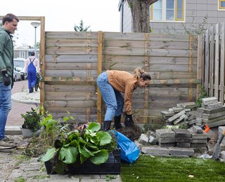 2 mensen die tegels wippen in de tuin