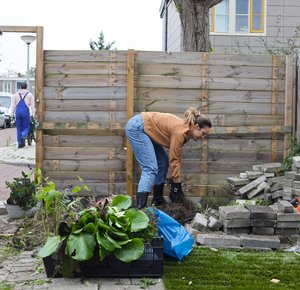 2 mensen die tegels wippen in de tuin