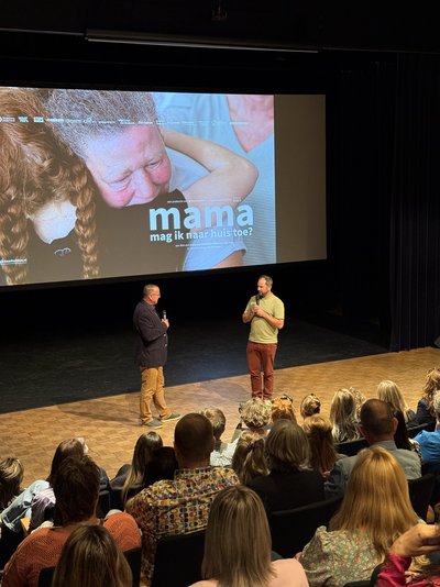 podium met 2 mensen en bioscoopscherm op achtergrond