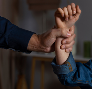 Hand omklemt arm die een gebalde vuist heeft