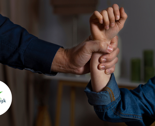 Hand omklemt arm die een gebalde vuist heeft